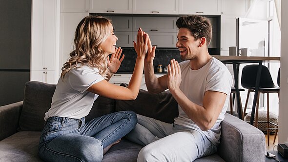 foto zeigt mann und frau auf couch sitzend