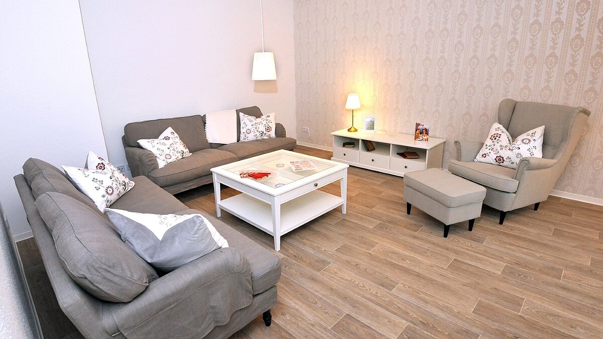 foto zeigt blick in ein wohnzimmer mit couch und sessel