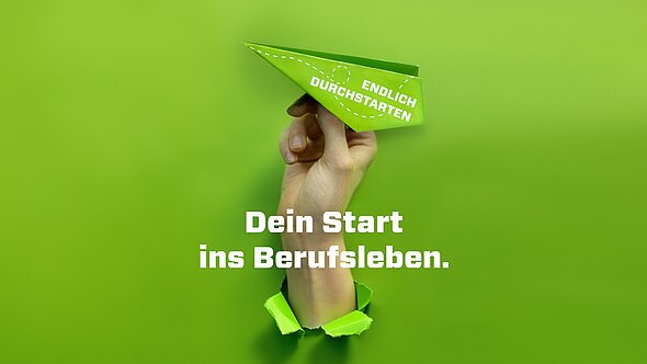foto zeigt eine hand mit einem grünen papierflieger