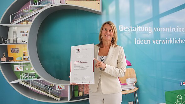 foto zeigt geschäftsführerin simone kalew mit dem zertifikat berufundfamilie in den händen