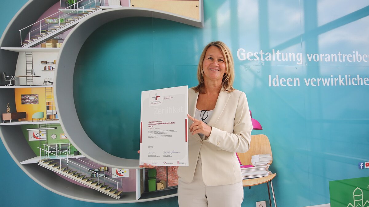 foto zeigt geschäftsführerin simone kalew mit dem zertifikat berufundfamilie in den händen
